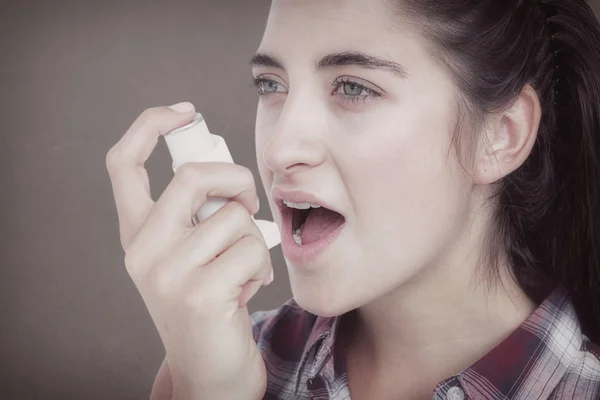 Mujer que tiene asma usando el inhalador de asma — Foto de Stock