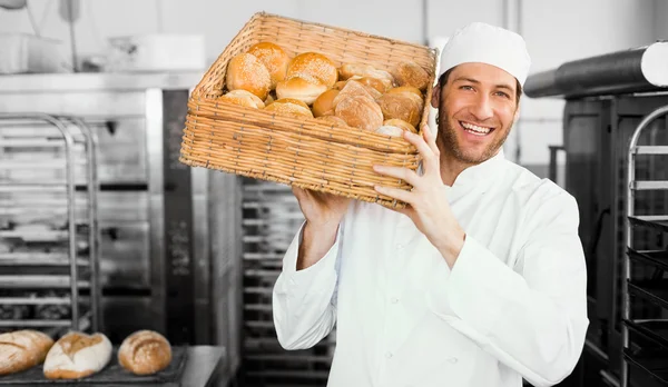 Baker holding basket of bread — Stock Photo, Image