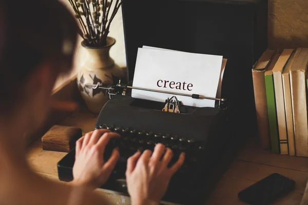 Crear contra mujer joven usando máquina de escribir — Foto de Stock