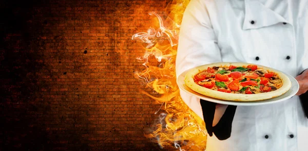 Mężczyzna szef kuchni oferuje pizzę — Zdjęcie stockowe