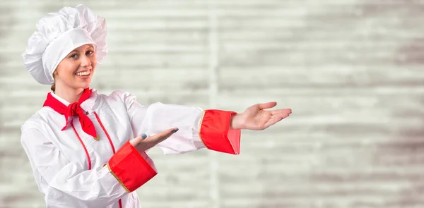 Pretty chef presenting with hands — Stock Photo, Image