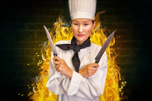 Female cook holding knives in kitchen — Stock Photo, Image