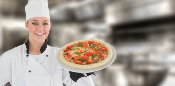 Kvinnan kock håller en pizza — Stockfoto