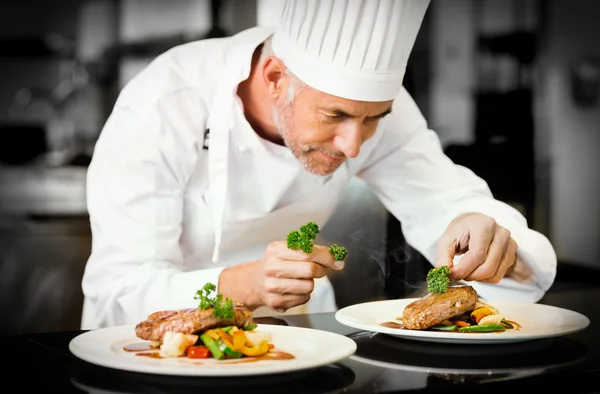 Konzentrierter männlicher Koch garniert Essen in der Küche — Stockfoto