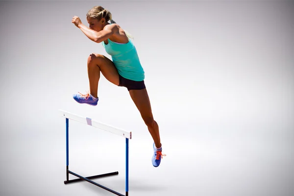 Vrouw van de atleet een hindernis springen — Stockfoto