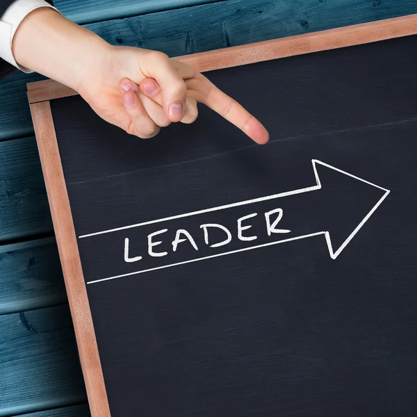 Hand pointing against blackboard — Stock Photo, Image