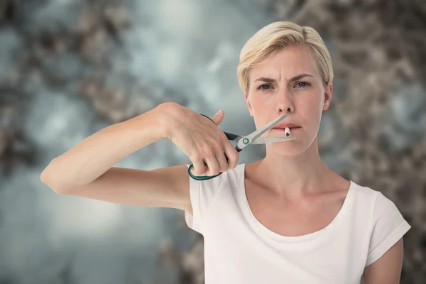 Vrouw snijden sigaret met een schaar — Stockfoto