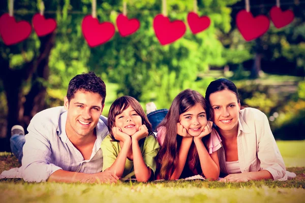 Familie liggen in park — Stockfoto