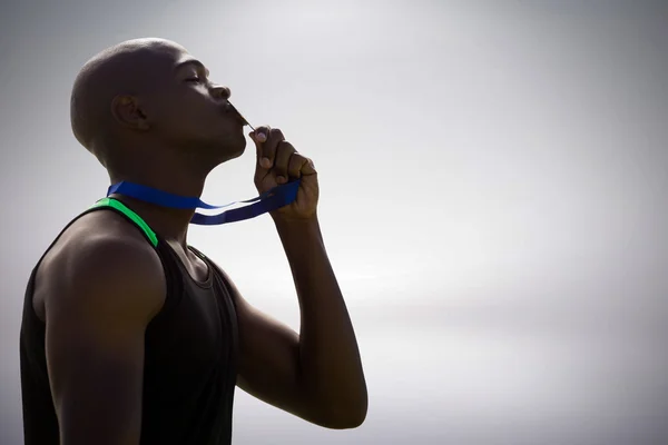 Homem atlético beijando sua medalha de ouro — Fotografia de Stock