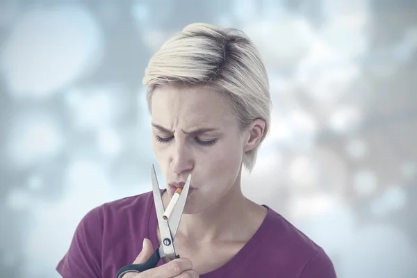 Красивая блондинка режет сигарету — стоковое фото