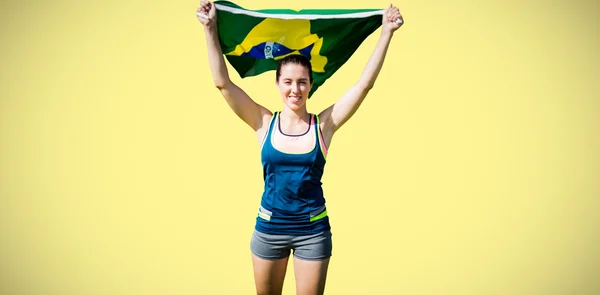 Sportvrouw verhogen Braziliaanse vlag — Stockfoto