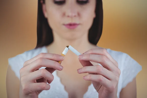 Vrouw uitlijnen sigaret doormidden — Stockfoto