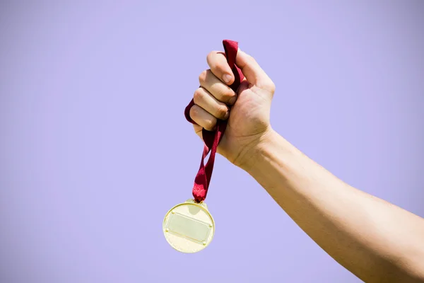 Hand hält eine Goldmedaille — Stockfoto