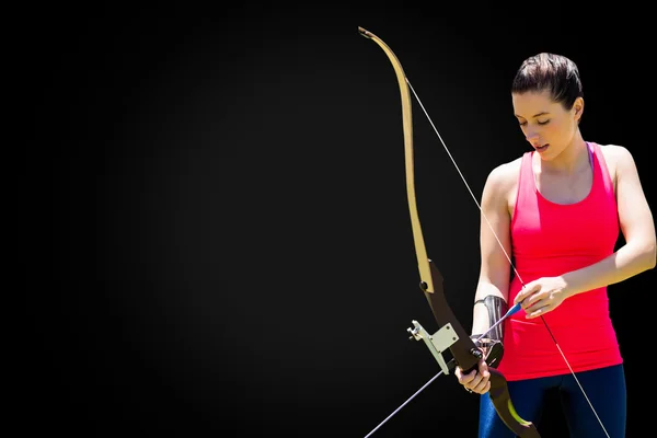 Mulher atlética praticando tiro com arco — Fotografia de Stock