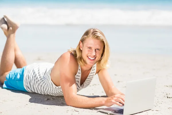 男子在海滩上使用便携式计算机 — 图库照片