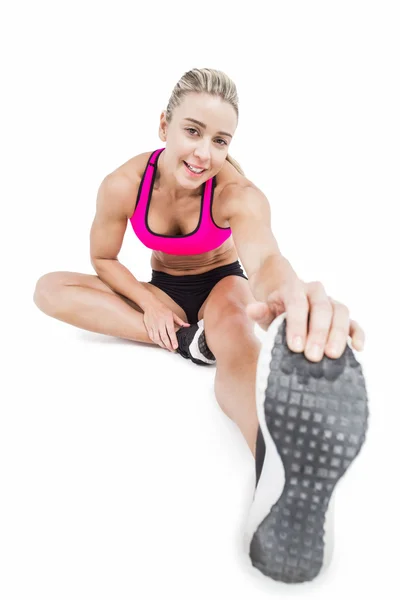 Atleta feminina sentada e alongada — Fotografia de Stock