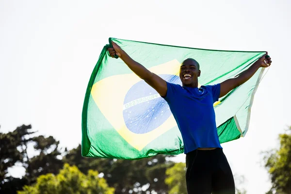 Спортсмен позирует с бразильским флагом — стоковое фото