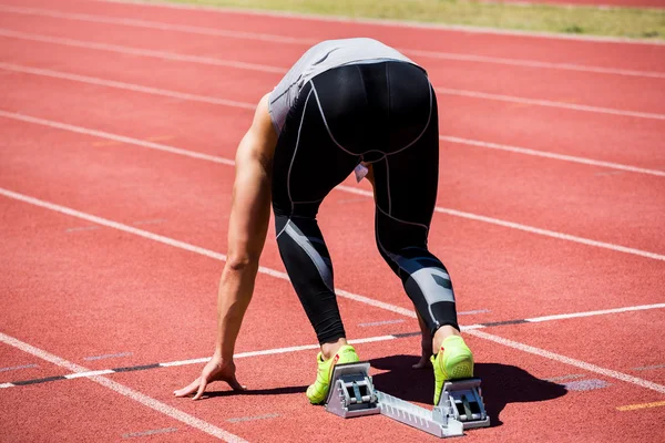 Athlete on starting block about to run — Stock Photo, Image