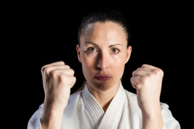 Female fighter performing karate stance clipart