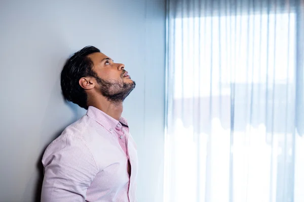 Businessman standing against wall — Stock Photo, Image