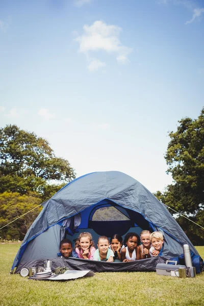 Bambini sorridenti sdraiati insieme nella tenda — Foto Stock