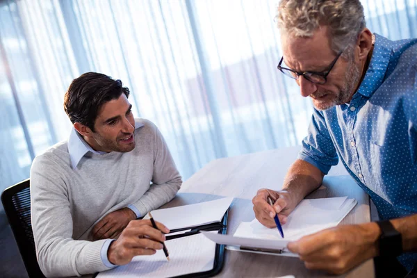 Dos hombres de negocios leyendo un documento — Foto de Stock