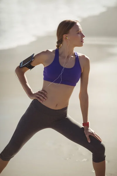 Fit woman warming up on beach — Stock Photo, Image