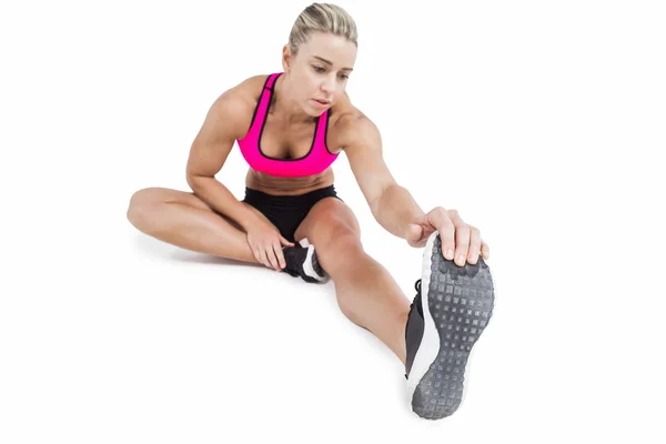 Female athlete sitting and stretching — Stock Photo, Image