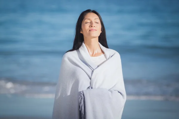 Junge Frau steht am Strand — Stockfoto