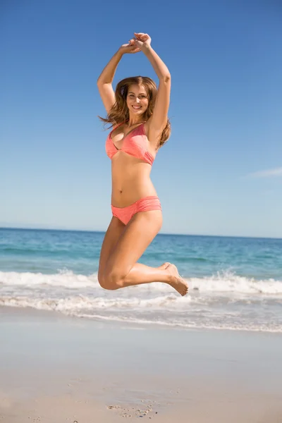 Young woman jumping on beach — Stock Photo, Image