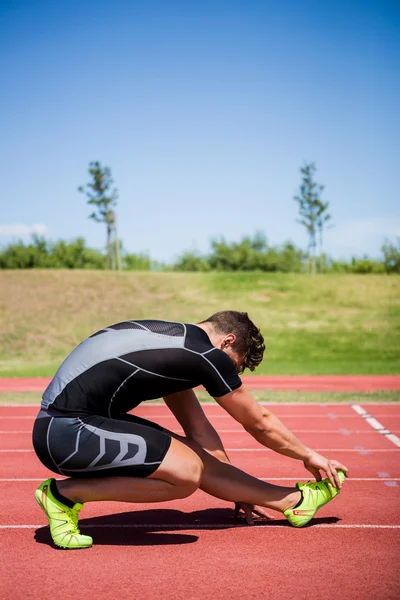 Atleta aquecendo na pista de corrida — Fotografia de Stock