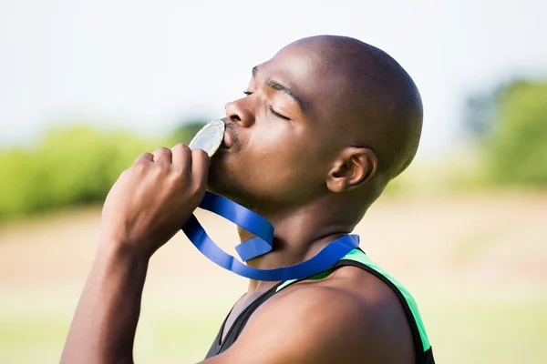 Athlete kissing his gold medal — Stock Photo, Image