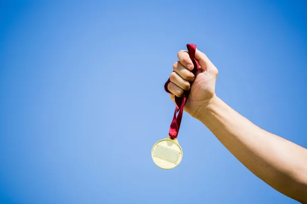 Athlet hält Goldmedaille in der Hand — Stockfoto