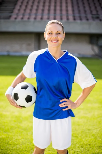 Kvinnliga fotbollsspelare håller en boll — Stockfoto