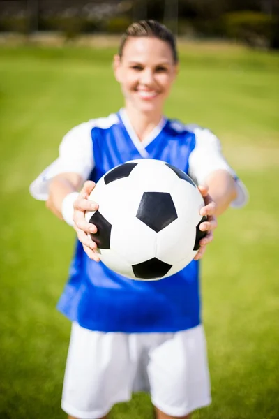 Футболистка, стоящая с мячом — стоковое фото