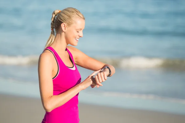 Vrouw tijd controleren op strand — Stockfoto