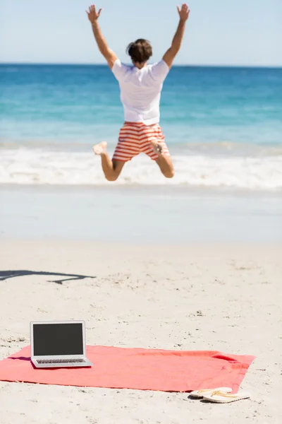 Мужчина прыгает по пляжу — стоковое фото