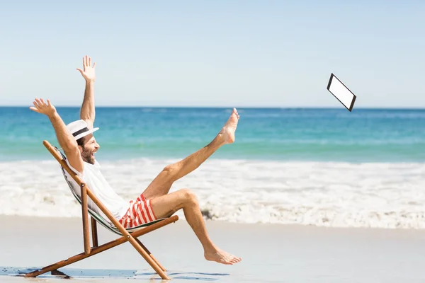 Uomo lancio tablet sulla spiaggia — Foto Stock