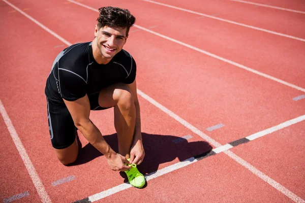 Чоловік-спортсмен зав'язує шнурки взуття — стокове фото