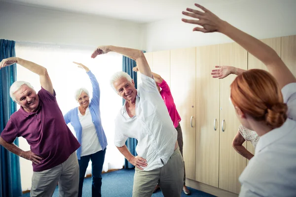 Seniors doing exercises with nurse — Stock Photo, Image