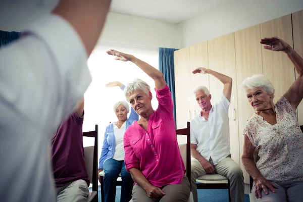 Idosos fazendo exercícios com enfermeira — Fotografia de Stock