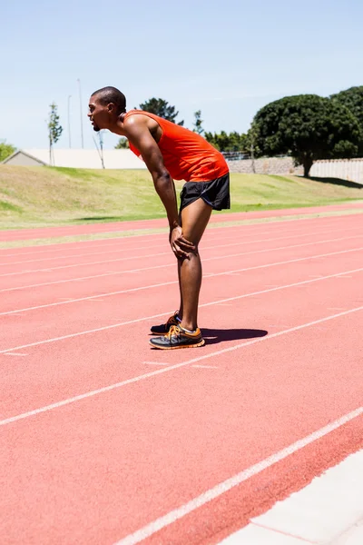 Atleta cansado parado en pista de atletismo —  Fotos de Stock