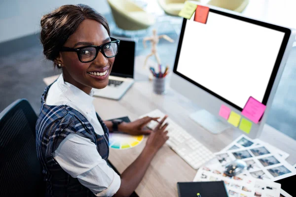 Glimlachende zakenvrouw met behulp van een computer — Stockfoto