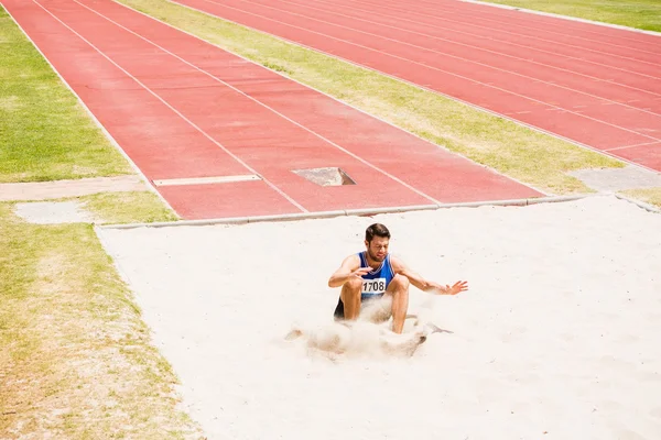 Sportler landet auf Sandkasten — Stockfoto