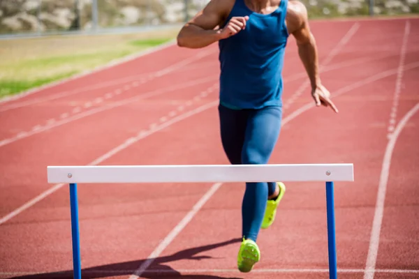 Athlete ready to jump hurdle — Stock Photo, Image