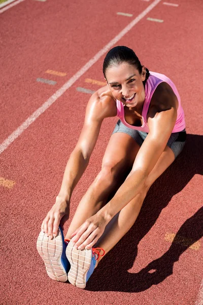Atleta feminina esticando o isquiotibial — Fotografia de Stock