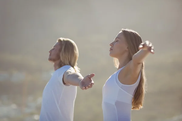 Man and woman performing yoga — Stock Photo, Image