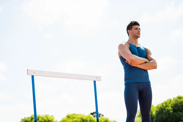 Atlet stående med krydsede arme - Stock-foto
