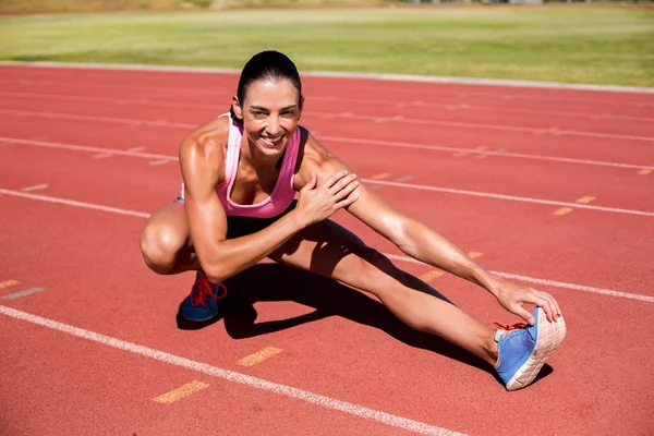 Atleta femminile tendendo tendine del ginocchio — Foto Stock