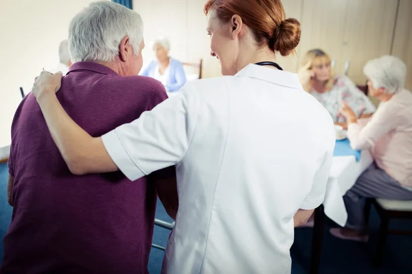 Meewerkende senior verpleegkundige met behulp van walker — Stockfoto
